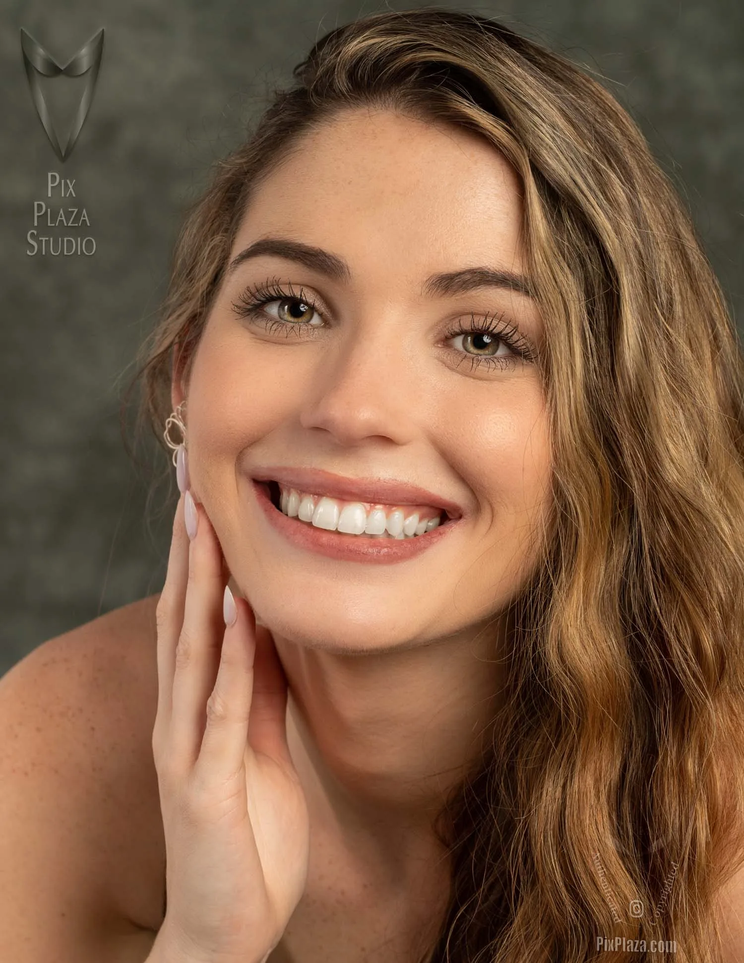 Beautiful young woman looking at the camera close up with her fingers touching her jaw